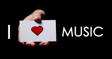 A hand showing a romantic card saying "I love Music". Concept: love of music,...