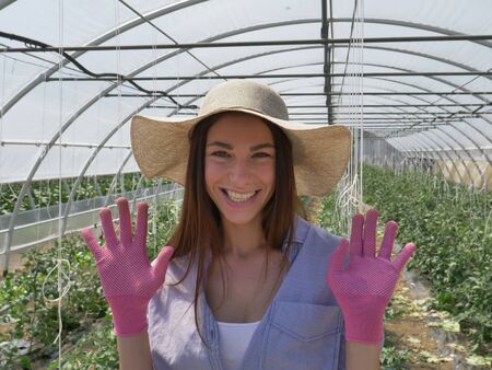 Portrait of a beautiful young woman in a straw hat. Concept: bio products, natural products, fresh, delicious, fruits, vegetables, grow, water, plants.の写真素材
