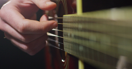 A musician plays classical guitar and practice to play better and better. The guitarist plucks the...