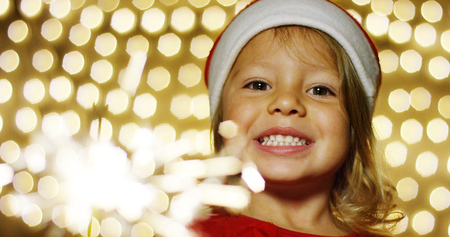 girl plays with a flare sparkling smiles of joy for the New Year celebrations, they are happy of the holiday season. waiting for Santa Claus love for Christmas.の写真素材