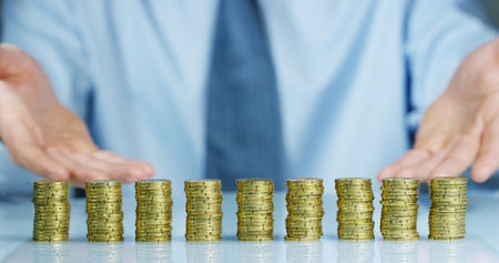 Has been a lot of stacks of gold coins. The businessman counts and watches the money carefully....