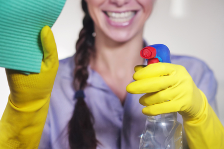 A beautiful woman struggling with house cleaning on glass. Concept of: cleaning, perfection, domestic crafts, cleaning products.の写真素材