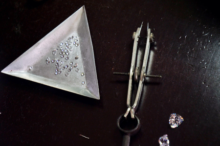 Close-up of a goldsmith's work table on which they are supported: high-quality diamonds, and precision tools for producing luxury jewelery. Concept of: tradition, luxury, jewelry.の写真素材
