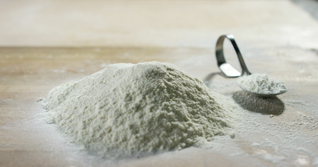flour with a spoon and an eggの写真素材