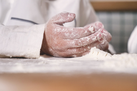 Hands of a little girl in the kitchen, playing with her hands. Concept of: nutrition, cooking school, education and game.の写真素材