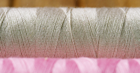 Macro shot of colorful rolls with sewing thread fabrics. The rolls come in all colors and shades with sewing and thread all kinds of Wigs. Concept: tailoring, tradition, color, fashion, clothingの写真素材