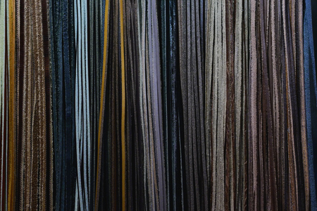 In a textile shop, there are fabrics of various colors and various materials, such as fabric, lace, satin, linen. Concept of: tailoring, colors, fabrics, clothes and fashion.の写真素材