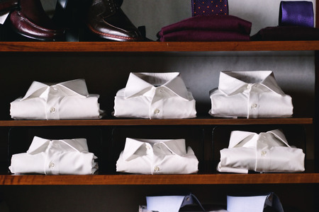 Close up of new white folded shirts on a shelf. concept: fashion, tailor, shoppingの写真素材