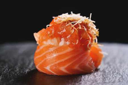 Macro shot of sushi, sashimi, uramaki and nighiri. typical Japanese dish consisting of rice, salmon or tuna, shrimp and fish eggs soaked in soy. Concept: Japanese restaurant, sushi, oriental tradition.の写真素材
