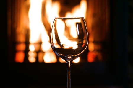 In winter, before the fireplace, tasted red wine in a glass. Concept of: relax, restaurant, wine, sommelier.の写真素材