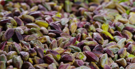 Macro of heap of pistachio, green, purple, yellow. Concept: salted, nuts, seeds, delicious, healthy, growing on the "tree of life", fresh product, growing in Central Asia, proper nutritionの写真素材