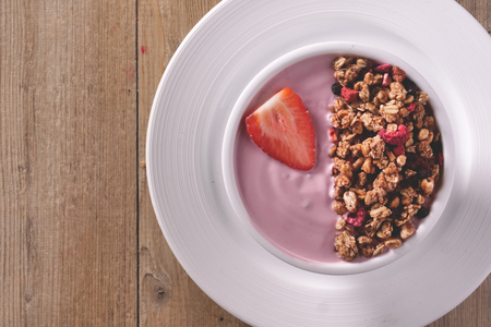 Composition of a typical genuine breakfast made with strawberry yogurt and granola. Concept of: fitness, diet, wellness and strawberries.の写真素材
