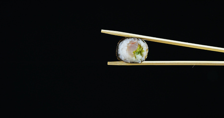 Macro shot of sushi, sashimi, uramaki and nighiri.typical Japanese dish consisting of rice, salmon or tuna, shrimp and fish on black background.Concept: Japanese restaurant, sushi, oriental traditionの写真素材