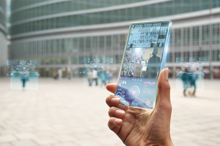 The hand of a woman in suits, uses a futuristic glass with the latest advanced holographic...