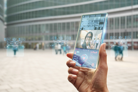The hand of a woman in suits, uses a futuristic glass with the latest advanced holographic technology.の写真素材
