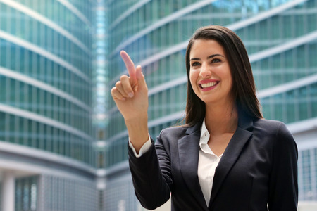 A business woman looking at a holographic and futuristic chart. Concept of: future, holographyの写真素材