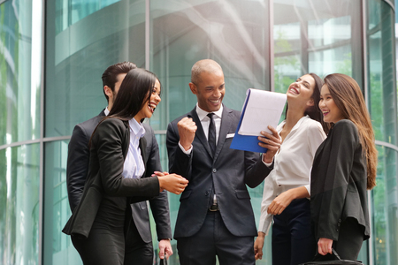 A group of business people from different backgrounds to rejoices and celebrates their success in financial and economic fields. Concept of: team work, internationality and success.の写真素材