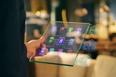 Television close-up of a tablet with the control of all the functions of the house such as wi-fi, heating, lighting, and television through holography. Concept of, home automation, automations, future, technology.の写真素材