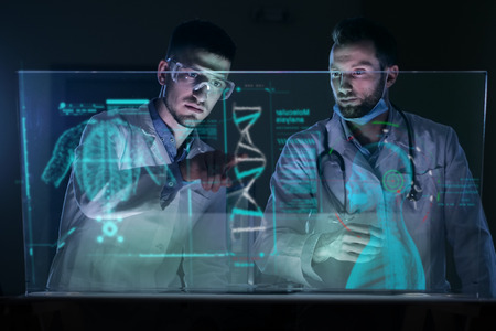 A couple of doctors or scientists analyze the patient's medical situation. Concept of: medicine, doctors, future, holography.の写真素材