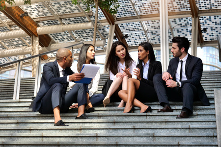In a moment of relaxation for business people from different ethnic groups, dressed in suits and...