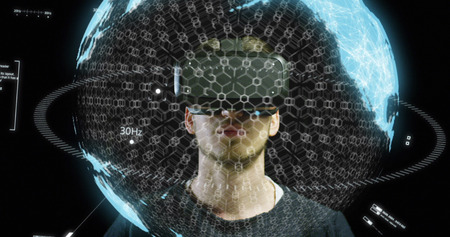 Young man with virtual reality glasses enjoys his trip in an adventurous world on a dark background....