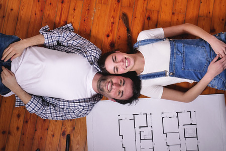 Lying on the floor. The couple are smiling and happy with the future project together.の写真素材