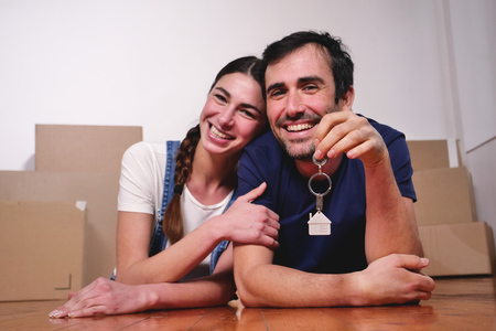 They are just a house and they are moving. The bride and groom smile and hold the keys to the new house. Concept of: future, familyの写真素材