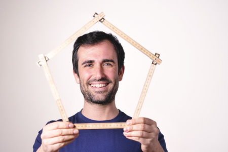 A man who has just bought a house and is moving. the woman smiles and holds the house. Concept of: future, new home, mortgage and loan.の写真素材