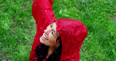 girl smiles, spins and laughs in the rain. the rain falls, the drops fall on his face and the girl is happy with life and nature around. concept of nature and happy life. Adventure, purity.の写真素材