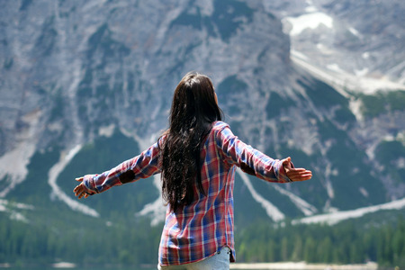 A beautiful woman makes trekking and explores the nature around her. The woman is happy and enthusiastic about her. Concept of: freedom, exploration, breathの写真素材