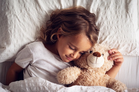 A beautiful girl sleeps and has her dreams. The girl smiles because she is relaxed and sleeps well. Concept of: relax, love sleep.の写真素材