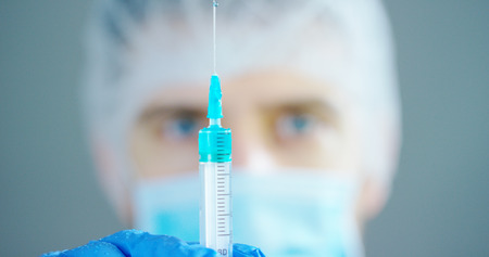 doctor or scientist in laboratory holding a syringe with liquid vaccines for children or older adults, or cure animal diseases.の写真素材