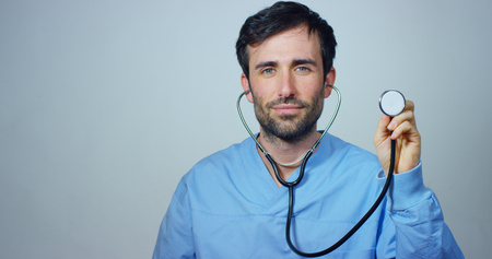 A doctor shows stethoscope and appears. Concept: future, medicine, heart, disease and care and global health care and life.の写真素材