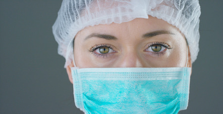close up portrait of a woman surgeon or doctor with mask ready for operation in hospital or clinic.の写真素材