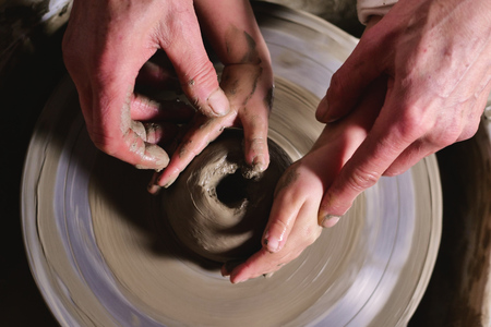 A magical moment in which a father works in creating vases teaches how to make a vase and passes on to the ancient tradition of creating works of art from generation to generation.の写真素材