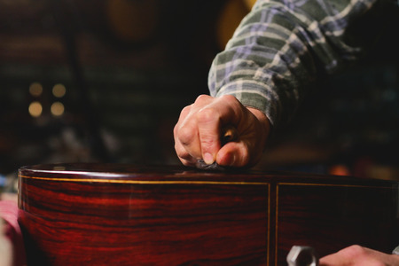 In his laboratory, a liutist builds high quality guitars for musicians, working fine wood. Concept of: music, tradition, ancient crafts.の写真素材