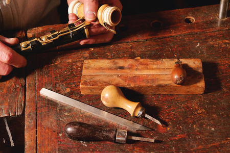 A flute maker builds sweet flutes and crosspieces, made exclusively by hand and precious wood or ivory, in his own laboratory. Concept of: music, craftsmanship, traditionの写真素材