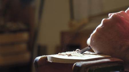 The professional violin master makes a violin with his own hands, spruce, pine, glasses, planes,...