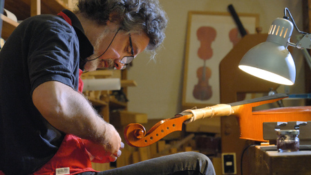 The professional violin master makes a violin with his own hands, spruce, pine, glasses, planes, tunes strings. Concept: spiritual instrument, made hands, art, music, melody, soundの写真素材