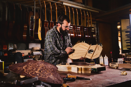 In his laboratory, a liutist builds high quality guitars for musicians, working fine wood. Concept of: music, tradition, ancient crafts.の写真素材