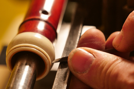 A flute maker builds sweet flutes and crosspieces, made exclusively by hand and precious wood or ivory, in his own laboratory. Concept of: music, craftsmanship, traditionの写真素材