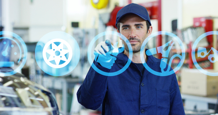 A futuristic portrait of an auto mechanics assistant, works with a hologram 24 hours a day, buying and selling spare parts online, in a car workshop. Concept: the technology of the future.の写真素材