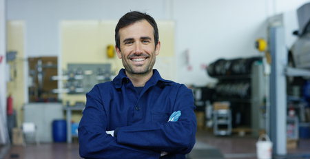 Portrait of a young woman in a car workshop, in the background of a car service.の写真素材