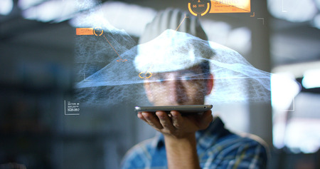 A worker uses a future technology platform to verify the design in holography and augmented virtual reality. Concept: future technology, multimedia technology, futuristic engineering.の写真素材