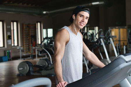 With a lot of energy on a treadmill. Concept of: sport, gym, muscles and fitnessの写真素材