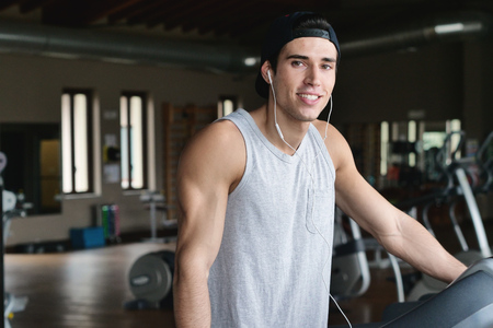 With a lot of energy on a treadmill. Concept of: sport, gym, muscles and fitness