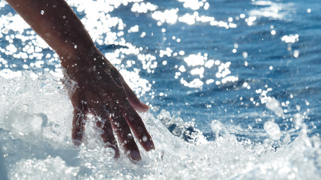 A wave touch girl, a background of blue sea waterの写真素材