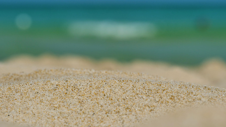 Brown sand on a background of blue sea water.