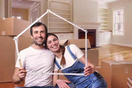 Just love a house and is moving. The bride and groom smile and hold the outline of a house. Concept of: home, family, ecologyの写真素材