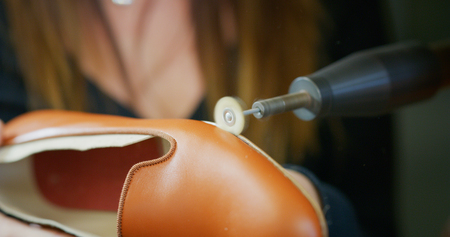 In a shoe factory. Close up of a shoemaker while in a shoe factory. Concept: handmade, fashion, industrial, factory.の写真素材
